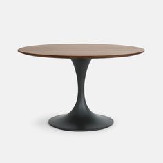 an oval wooden table with black base