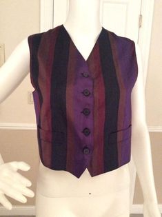 Luxurious silk vest to layer over a blouse to create the Gigli iconic layered romantic look. The jewel tones blend with other Gigli pieces so well. Bronze, purple, burgundy, and black stripes allow it to mix with a variety of colors. The back of the vest is a bronze color. Working pockets on the front of the V notched front of the vest. Five black marbled flat button front closure Made in ItalyFully lined in bronze rayon.Measurements:Length - 21”Bust - 35”Waist - 32” Chic Fitted Striped Vest, Elegant Silk Vest For Formal Occasions, Formal Fitted Multicolor Top, Fitted Multicolor Top For Formal Occasions, Elegant Fitted Silk Vest, Fitted Silk Vest For Workwear, Fitted Silk Vest For Work, Silk Fitted Vest For Formal Occasions, Formal Fitted Silk Vest