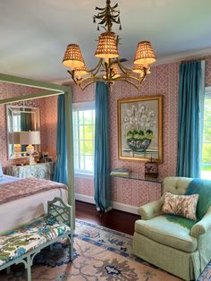 a bed room with a neatly made bed and a fancy chandelier above it