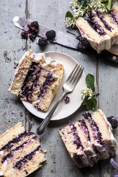 a piece of cake on a plate with berries and flowers next to it, cut into slices