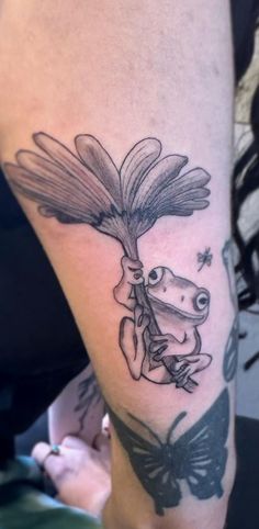 a frog with a butterfly on its leg