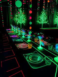 a long table is lit up with green and red lights, decorated with christmas trees