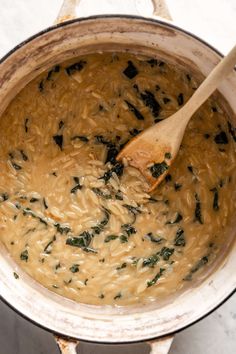 a wooden spoon in a pot filled with soup