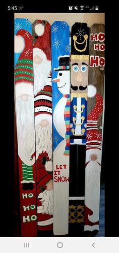 several snowboards with santa claus and other decorations on them, all painted in different colors