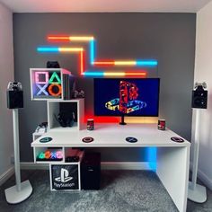 a computer desk with speakers and a television on top of it in a room that has carpeted flooring