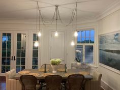 a dining room table with four chairs and a chandelier hanging from the ceiling