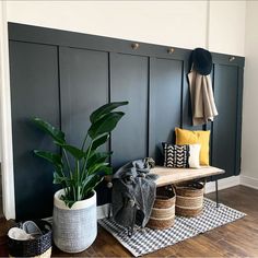 a wooden bench sitting next to a green plant on top of a hard wood floor