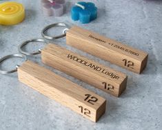 three wooden keychains with numbers on them sitting next to some rubber erasers