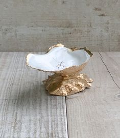 a white and gold bowl sitting on top of a wooden table