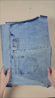 someone is holding an old pair of jeans with holes in the bottom and side pockets