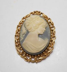 "Gorgeous vintage gold tone framed cameo brooch. Oval ornate frame is 1 3/4\" x 2\". Blue plastic background with a white cameo. Excellent condition. Unsigned." Vintage Cameo Jewelry, Yellow Gold Oval Cameo Brooch, Collectible Oval Cameo Brooches, Elegant Gold Cameo Brooch, Giraffe Ring, Collectible Oval Cameo Brooch, Collectible Cameo Pendant Brooches, Wife Jewelry, Blue Beaded Necklace