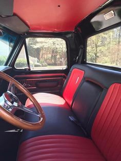 the interior of an old truck with red leather seats