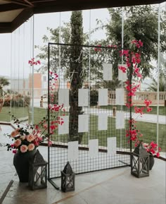 flowers and candles are on display in front of a glass wall with notes attached to it