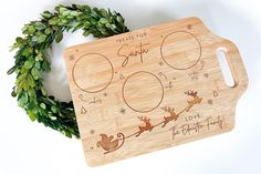 a wooden cutting board with christmas designs on it and a wreath around the edges that says, treats for santa