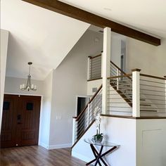 an empty living room with wood flooring and white walls, stairs leading up to the second floor