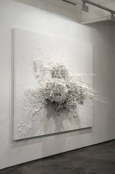 an abstract painting is hanging on the wall in front of a black and white background