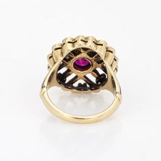 This is part of Chairish’s Fine Jewelry assortment.  Elegant and finely detailed Edwardian era enamel ring (circa 1900s to 1910s), crafted in 14 karat yellow gold.    Created ruby measures 5mm (in very good condition and free of cracks or crisps). Small natural 1mm seed pearls surround the ruby.   A created ruby is set into a beautifully detailed scrolled mount. Blue and black enamel adds a pop of colour, offering contrast to the ruby that is striking and unique. The ring is small in size (2 1/2 Victorian Enamel Ring For Anniversary, Heirloom Yellow Gold Ruby Signet Ring, Heirloom Ruby Signet Ring In Yellow Gold, Antique Ruby Signet Ring, Victorian Enamel Wedding Ring, Victorian Style Hallmarked Enamel Ring For Anniversary, 14k Yellow Gold Ruby Ring With Intricate Design, Victorian Yellow Gold Enamel Ring For Anniversary, Victorian Yellow Gold Ruby Ring With Intricate Design