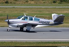 a small silver plane is sitting on the runway and ready to take off from the airport