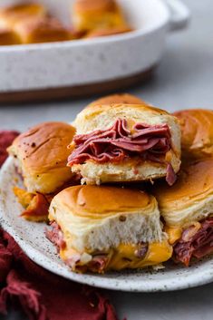 several sandwiches stacked on top of each other on a white plate with red napkins