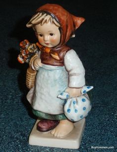 a ceramic figurine is holding a basket