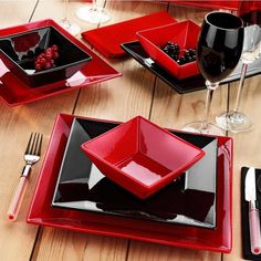 a table set with red and black dishes