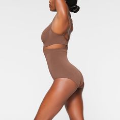 Shape your curves and feel supported in this stretchy shapewear high waisted brief with strong targeted compression at the tummy and waist, butt-shaping pockets, and a silicone interior underband that keeps it from rolling down. Hits right below the bust and features a wider crotch for added coverage and a cotton gusset. Fits true to size. | SKIMS High-Waisted Brief | Medium Neutral | Seamless Sculpt