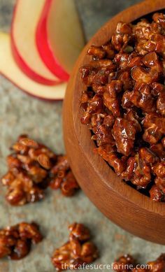 walnuts in a wooden bowl next to an apple