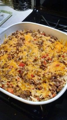 a casserole dish with meat and cheese in it sitting on the stove top