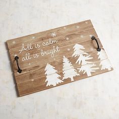 a wooden sign that says, all is calm all is bright with white trees on it