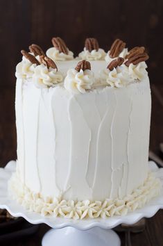 a white cake with frosting and pecans on top