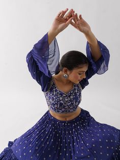 A three-piece Purple lehenga set from the Suruchi Parakh collection. This elegant georgette crepe lehenga is paired with a hand-embroidered blouse. The outfit is completed with a matching georgette crepe dupatta. The bell sleeve blouse has a cutwork neckline. And, the purple dupatta has a beautiful touch of ruffle with an embellished border. Semi-stitched Georgette Sets With Zari Work, Bollywood Style Georgette Sharara For Reception, Fitted Pre-draped Saree With Dabka Work For Party, Georgette Palazzo Set With Mirror Work, Bollywood Georgette Sets With Zari Work, Georgette Sharara For Reception In Transitional Season, Festive Georgette Sets For Reception, Reception Georgette Palazzo Set With Zari Work, Georgette Palazzo Set With Zari Work For Reception