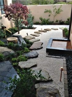 a small garden with rocks and gravel in the foreground, surrounded by shrubbery