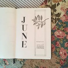 an open book with the word june written in black ink on top of floral fabric