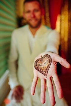 a man holding out his hand with a heart painted on it