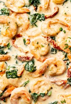 a pizza with shrimp, spinach and cheese on it's crust in a white sauce