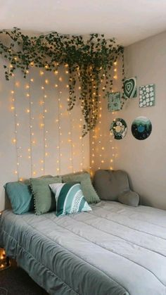 a bed sitting under a tree with lights on the wall next to it's headboard