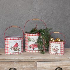 three metal buckets with christmas decorations on them