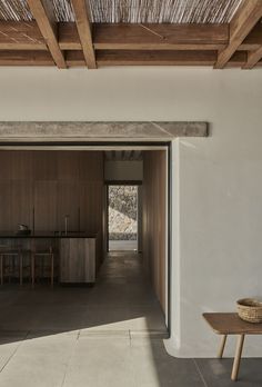 an open door leading to a kitchen and dining area with wood accents on the ceiling