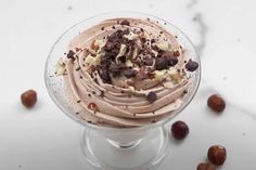 an ice cream sundae with nuts and chocolate chips on top in a glass dish