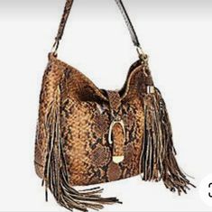 G.I.L.I. Women's Leather Stirrup Hobo Bag With Fringe Detail. Color - Sienna Cobra. Slouchy Hobo Style. Fringe Details On Both Sides. Goldtone Hardware. Coordinating Stirrup With Hidden Magnetic Closure. Single Handle. Signature Removable Tassel. Back Slip Pocket With Snap Closure. Tan Lining Interior With Two Slip Pockets And One Zip Pocket. 12.5" Wide By 12" High And 4" Deep. Euc Hobo Style, Stirrups, Hobo Bag, Magnetic Closure, Snake Skin, Snap Closure, Leather Women, Zip Pockets, Bag Lady