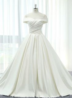 a white wedding dress on display in front of a window