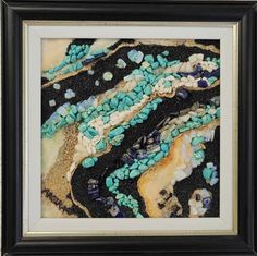 an abstract painting with blue and white rocks in the sand, framed on black paper