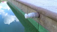 the water is reflecting the sky and clouds on the wall next to the pool area