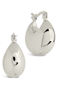 a pair of silver earrings with an oval shape and small tear shaped drop on the side