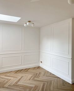 an empty room with white walls and wood floors