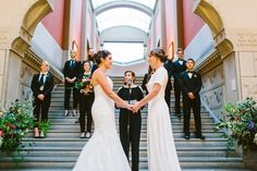 the bride and groom are holding hands on the stairs