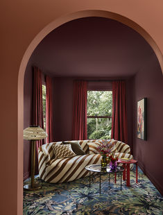 a living room filled with furniture and red curtains