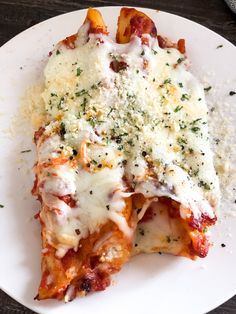 a white plate topped with lasagna covered in cheese