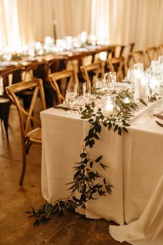 the table is set with candles and greenery for an elegant wedding reception or special event