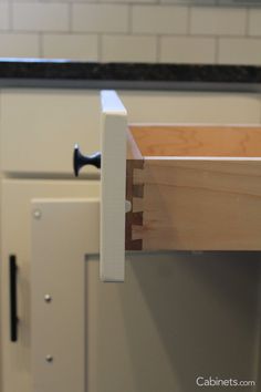 an open drawer on the side of a kitchen cabinet